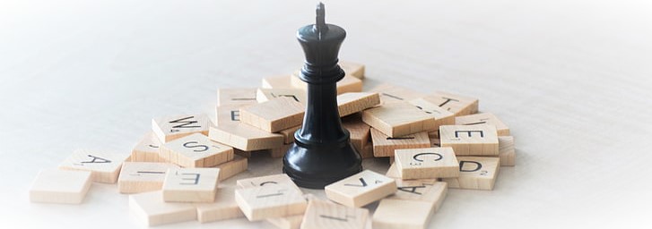 Melns šaha karalis starp Scrabble burtiņiem